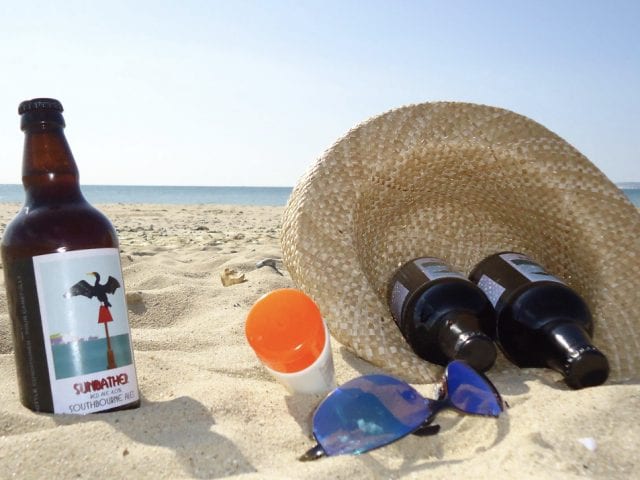 bottle on beach with hat and glasses