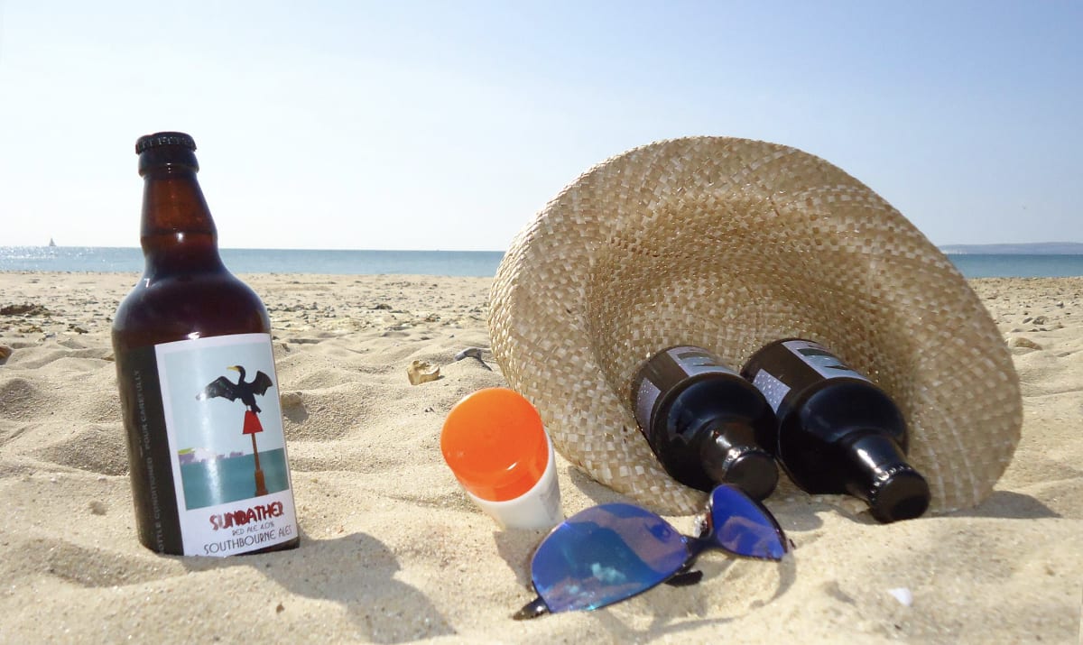 bottle on beach with hat and glasses