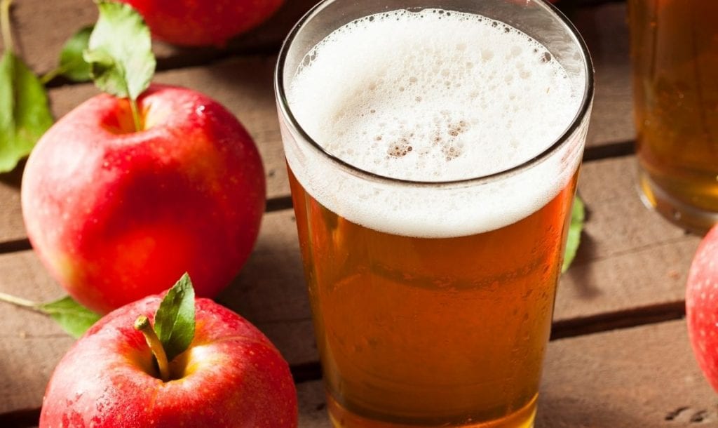 Glass of cider with some apples