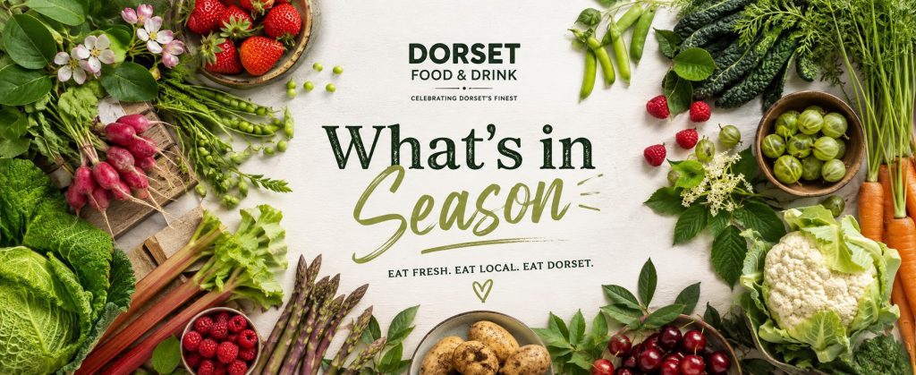 Seasonal English fruit and vegetables surrounding the Dorset Food & Drink "What's in Season" title on a wide website banner.
