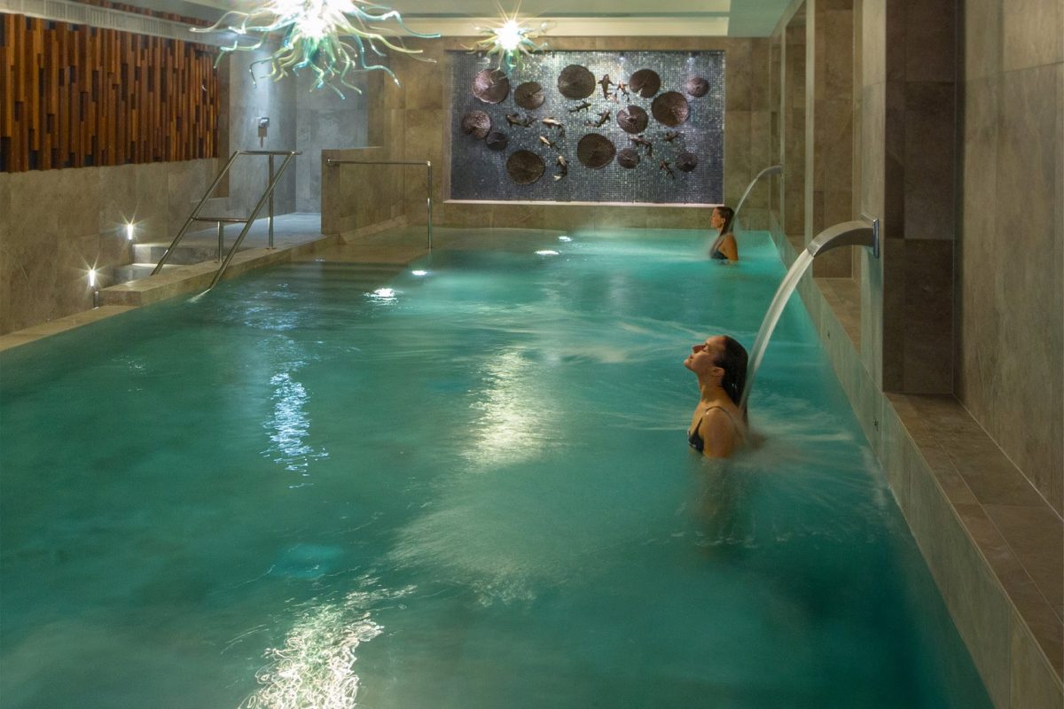Photo shows a pool in Monart Day Spa, Royal Pavilion, Poundbury, and people relaxing.