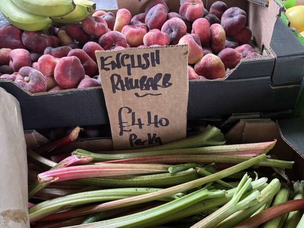 Locally grown rhubarb and seasonal fruit on display at a Dorset market.