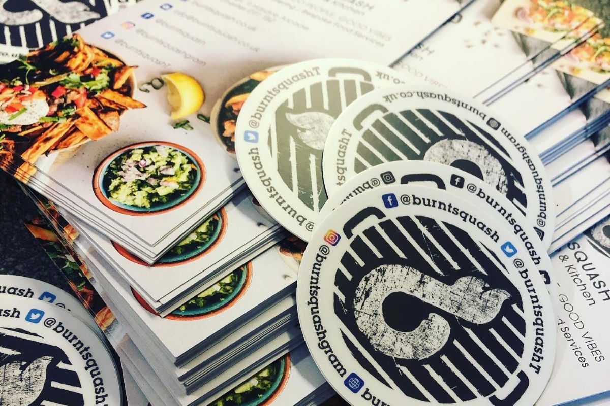 Branded Burnt Squash Kitchen & Bakery marketing materials, including business cards, stickers and promotional literature showcasing Dorset artisan bakery and catering services.