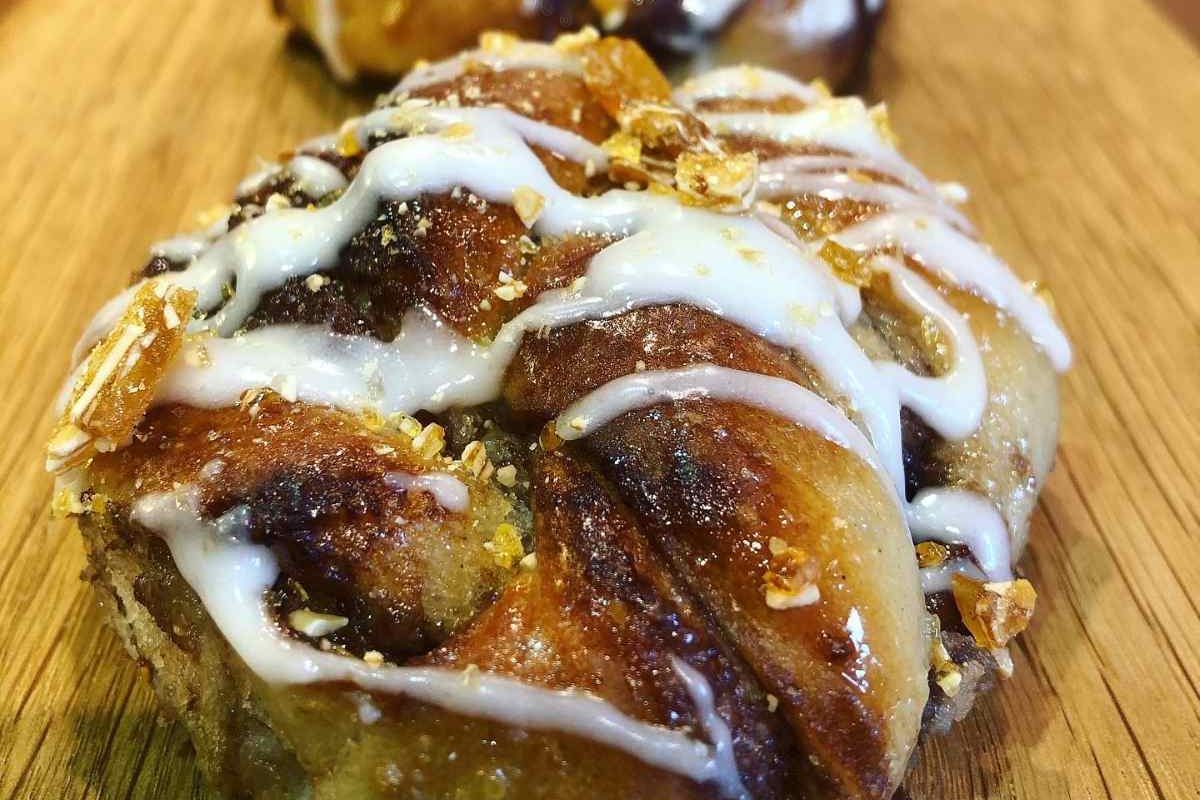 Freshly baked artisan cinnamon-style bun drizzled with icing and handmade by The Burnt Squash Kitchen & Bakery in Dorset.