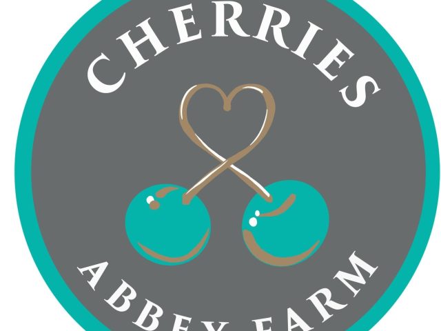 The Cherries at Abbey Farm logo featuring two turquoise cherries connected by heart-shaped stems. The design is set within a circular grey background bordered in turquoise, with the words "Cherries Abbey Farm" displayed around the edge.